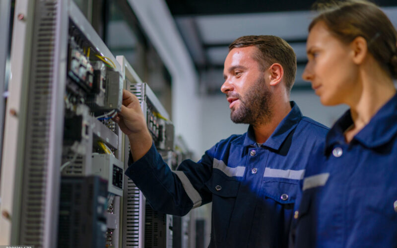 Two engineers checking network equipment in a server room