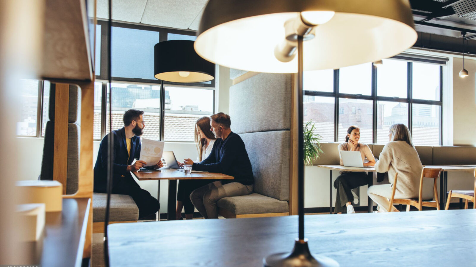 People meeting at tables in a bright flexible workspace café