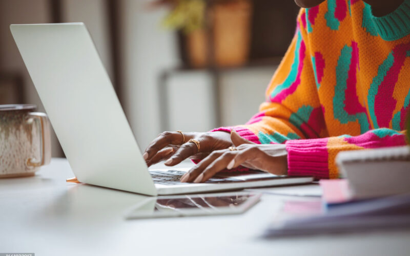 Close-up of hands typing on a laptop