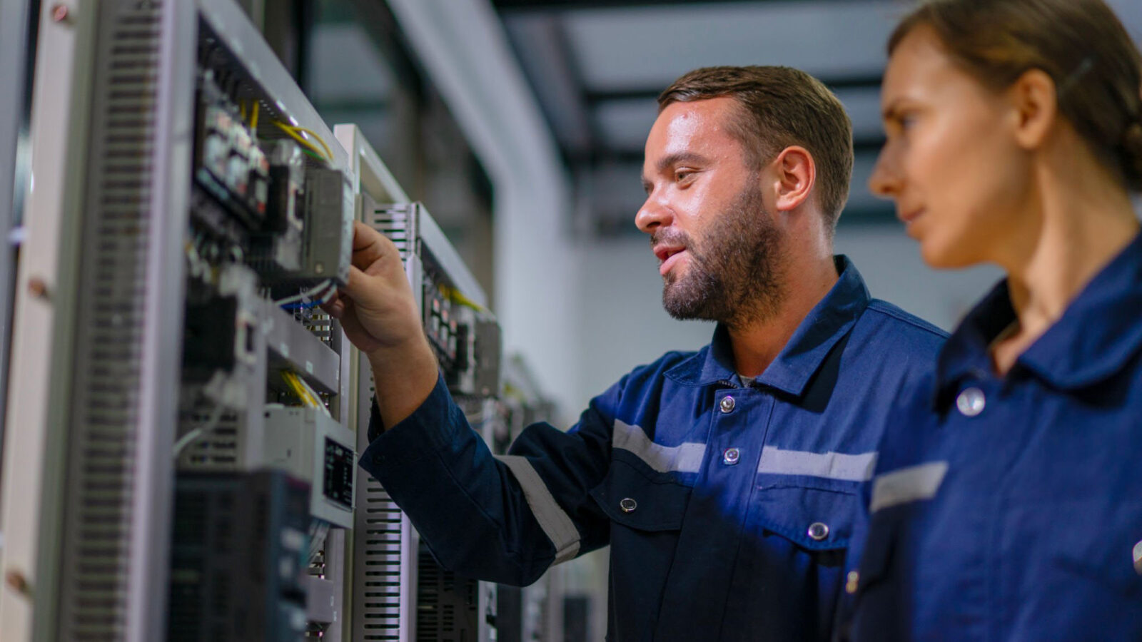 Two engineers checking network equipment in a server room